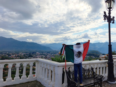 Latin Mexican boy of 8 years shows the flag of Mexico proud of his culture and tradition celebrates the national holidays of September 15 and Cinco de Mayoの写真素材