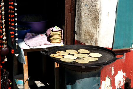 view of female indigenous hand making tortillas on comal, traditional foodの写真素材