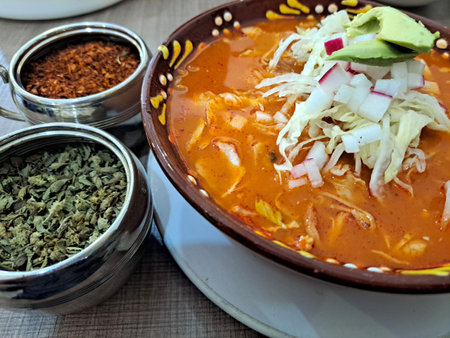Pozole is a traditional soup or stew from Mexican cuisine, with hominy, meat, and can be seasoned and garnished with shredded lettuce, chile peppers, onion, garlic, radishes, avocaの写真素材
