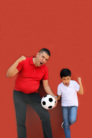 Latino dad and son share their love for soccer, they take a ball with their hands excited to watch the World Cup football gameの写真素材
