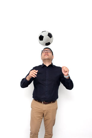 Latino adult office man plays with a soccer ball very excited that he is going to see the game and...