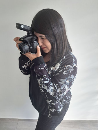 Latin adult woman takes pictures happy with professional camera as hobby and work of successful...