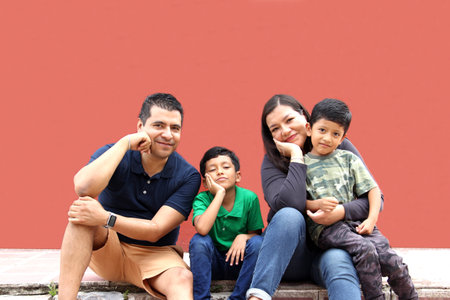 Latin, Hispanic family of mom, dad and children are sitting in the park they look happy enjoying quality time together in harmonyの写真素材