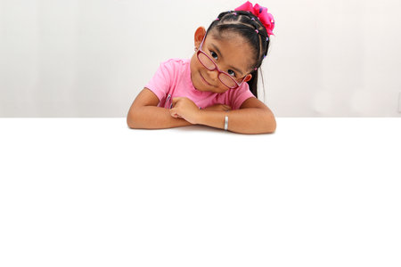 4 year old brunette latina girl shows smiling blank sign for message about education, against abuse, happy and respected childhood to change the worldの写真素材