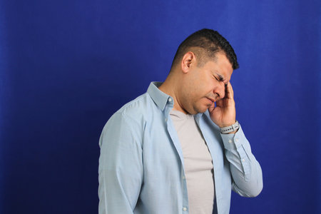 Forty year old brown latino adult man suffering from migraine disease headache, depression and...