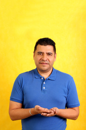 Dark-haired Latino adult man uses sign language typical of deaf people to establish a channel of communication with his social environmentの写真素材