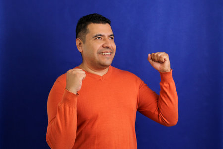 Latin adult man shows herself happy, blissful, lucky, satisfied, full, carefree, dances and shows...