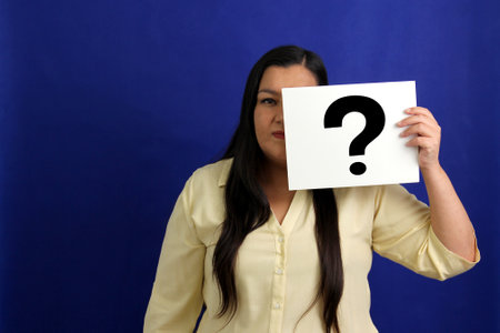 Latino adult woman shows a question mark, wonders, doubts, suspects, assumes, fears and distrusts