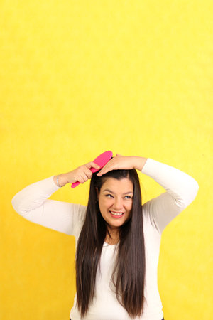 Adult Latina woman with very long hair worries and suffers while brushing because her hair falls...