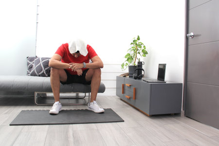 Latino adult man in his 40s takes a break while exercising having a healthy life to avoid diseases such as diabetes or hypertensionの写真素材