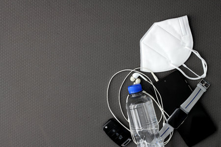 Fit objects to exercise in the gym prepared and protected such as a cell phone, watch, headphones and face masks to avoid contagionの写真素材