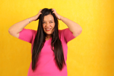 Adult 40-year-old Latina woman suffers from having damaged hair, she looks sad, desperate and anguished in search of treatmentの写真素材