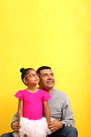 Divorced single brown dad carries his Latina daughter on his legs dressed as a ballerina, they play...