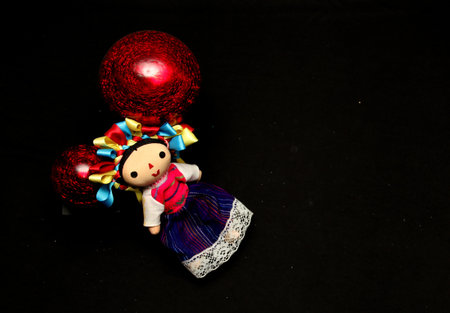 Mexican handmade doll, part of the Christmas decoration with poinsettia flowers as a frame for Christmas messages with canes and starsの写真素材