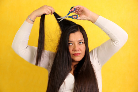 40 year old Latina woman with very long straight hair wants to cut her hair with scissorsの写真素材