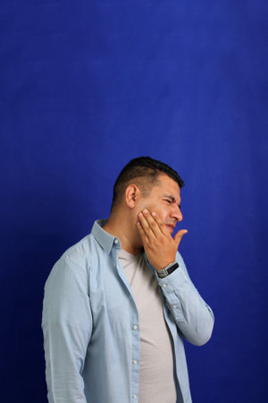 40-year-old brown Latino man suffers from toothache due to tooth decay or infection