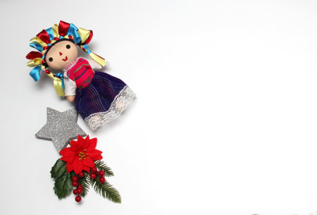 Mexican handmade doll, part of the Christmas decoration with poinsettia flowers as a frame for Christmas messages with canes and starsの写真素材