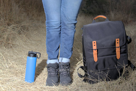 Backpack, thermos and boots for hiking in the mountains at sunrise, equipment for extreme outdoor sportの写真素材