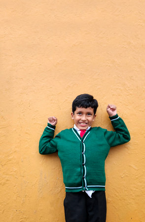 Dark-haired 9-year-old Latino boy in a public school uniform is excited and happy about the return to school ready to studyの写真素材