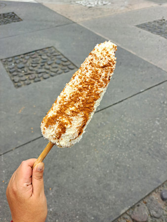 Corn cob and Mexican Elote is grilled corn on the cob slathered in a mayo, chili powder, cheese and lemon are sold from street carts in Mexicoの写真素材