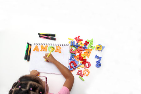 Girl plays with letters and forms the word Love as a representation of what children in Latin America needの写真素材