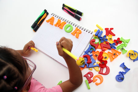 Girl plays with letters and forms the word Love as a representation of what children in Latin...