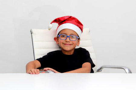 6 year old dark latino boy with eye glasses is ready to celebrate the holidays and write his letter...