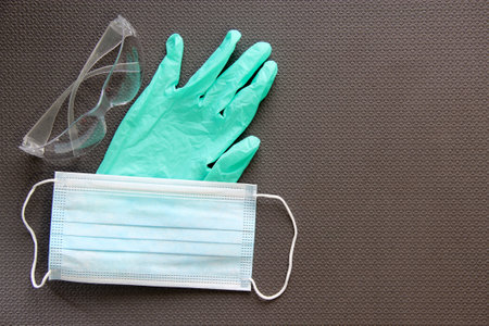 Latex gloves, glasses, face masks and antibacterial gel on gray background for virus protectionの写真素材