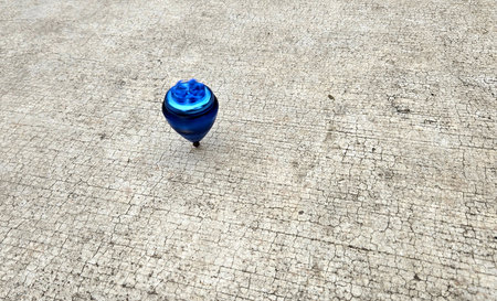 Blue spinning top, toy for children and adults, a type of spinning top that can rotate on one end, its gravitational center with a gyroscopic effectの写真素材