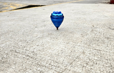 Blue spinning top, toy for children and adults, a type of spinning top that can rotate on one end, its gravitational center with a gyroscopic effectの写真素材