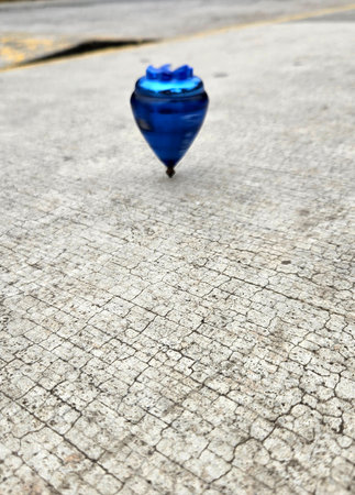 Blue spinning top, toy for children and adults, a type of spinning top that can rotate on one end, its gravitational center with a gyroscopic effectの写真素材
