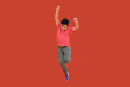 9-year-old Latino boy jumps and plays while doing physical activity to lose weight and improve his healthの写真素材