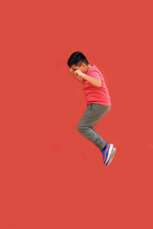 9-year-old Latino boy jumps and plays while doing physical activity to lose weight and improve his healthの写真素材