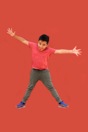 9-year-old Latino boy jumps and plays while doing physical activity to lose weight and improve his healthの写真素材