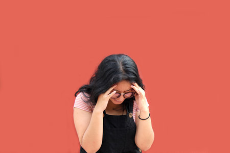 Young teenage woman suffers headache from depression and anxietyの写真素材