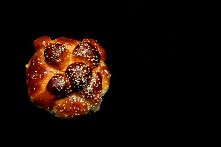 Delicious, fluffy and freshly made at home pan de muerto with sesame seeds sprinkled as a Mexican tradition for the Day of All Souls and All Saints which is celebrated in Novemberの写真素材