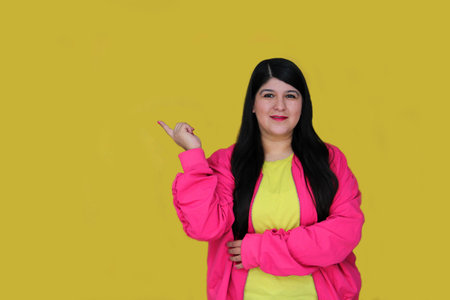 Excited and happy 30-year-old Latin woman shows and points with her hands to promotions and discountsの写真素材