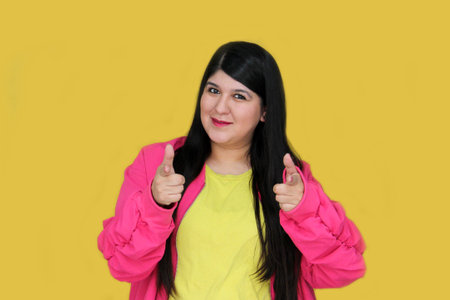 Latina 30 year old woman points finger at copy space for promotions and discounts
