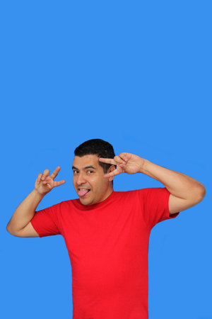 Dark-skinned Latino adult man makes the victory sign with his fingers happy and excited