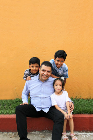 Divorced single dad has fun with his three dark-skinned Latino kids spending quality time and celebrating Father's Dayの写真素材