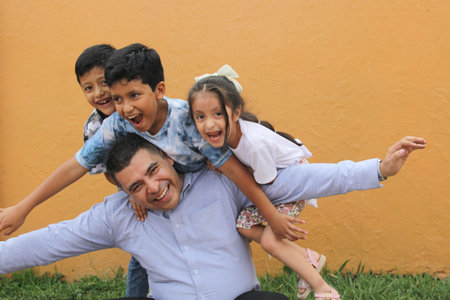Divorced single dad has fun with his three dark-skinned Latino kids spending quality time and celebrating Father's Dayの写真素材