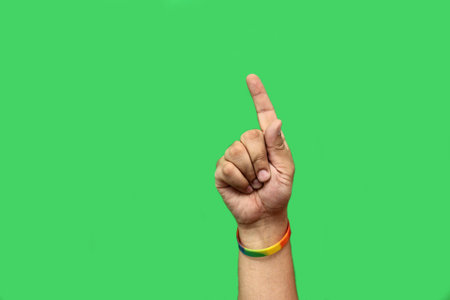 Hand with colorful bracelet as a symbol of the gay flag on the wrist points and signs ok and victory...