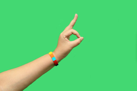 Hand with colorful bracelet as a symbol of the gay flag on the wrist points and signs ok and victory...