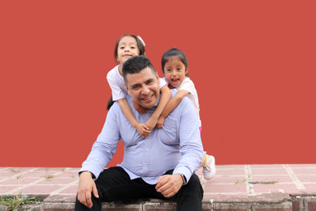 Divorced single dad plays with his two brunette Latina daughters show their love and celebrate Father's Dayの写真素材