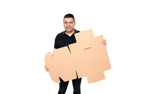 Latino adult man assembles a cardboard box following the instructions to achieve itの写真素材