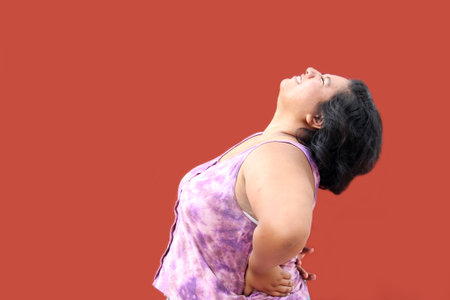 Young brunette Latin woman of 20 years old suffers from back, spine and neck pain due to tension and...