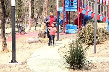 Divorced single dad walks and runs in the park with his 5-year-old brunette Latina daughter who has...