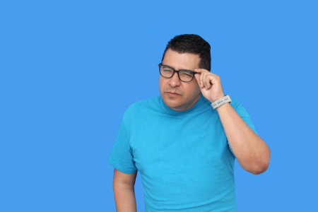 A 40-year-old dark-skinned Latino man uses eyeglasses to see better because he suffers from myopia...