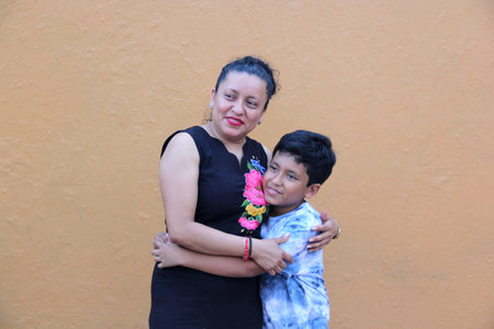 Brunette Latin mom with her 10 year old son hugging and showing their love and spending quality time celebrating Mother's Dayの写真素材