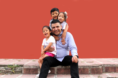 Latin family of a single dad with his 2 daughters and a son are happy and celebrate their day in povertyの写真素材